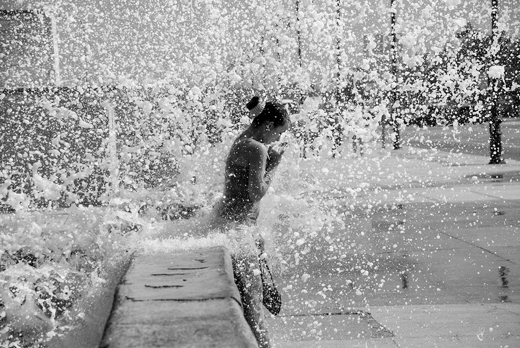 home The surprise of a mischievous wave playing with a girl on the Havana Malecón